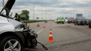 bil med innklemt front på motorveg og varselmarkering