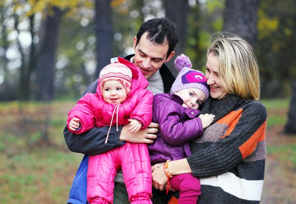 Familie på fire i park om høsten