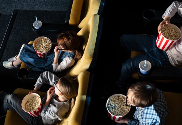 Gruppe med barn på kino som spiser popkorn