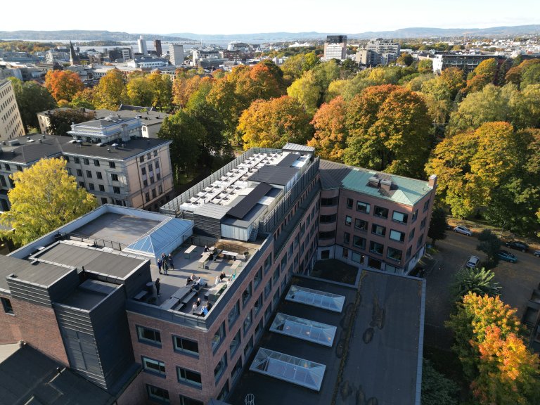 Luftfoto av bygget vårt i Oslo. I bakgrunnen er sentrum og fjorden.